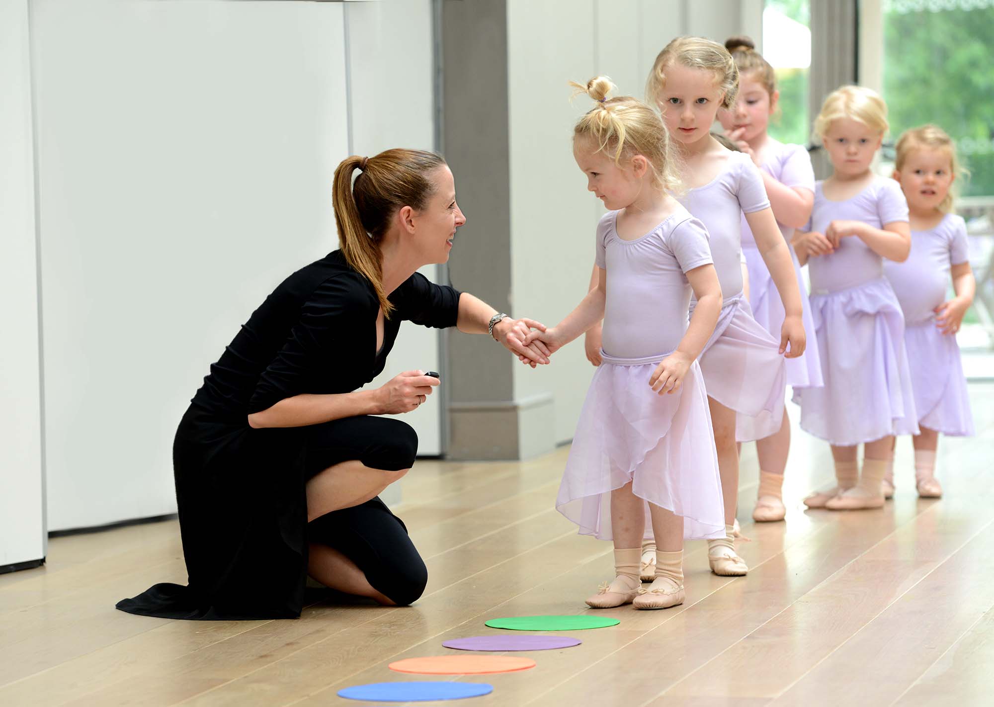 A parent watching a child's dance class through the door at Intune Dance